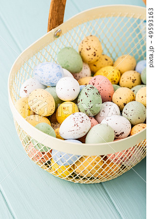 Metal basket with colourful Easter quail eggs 49593163