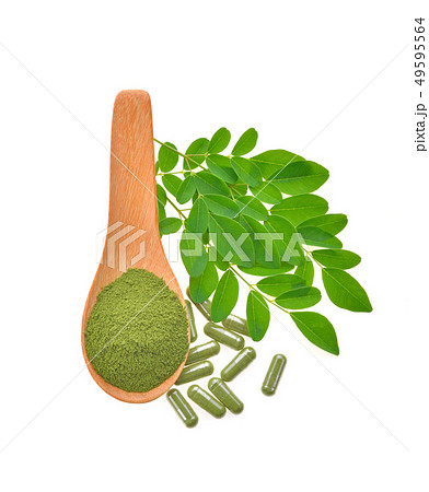 moringa leaf and powder capsule on  white 49595564