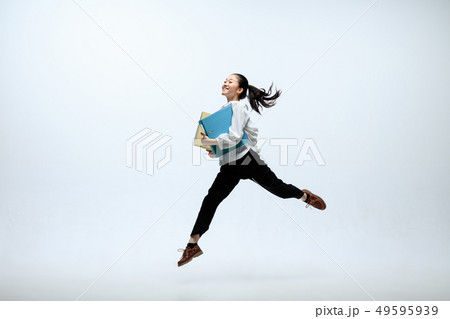 Woman working at office and jumping isolated on studio background Woman working at office and jumping isolated on studio background 49595939