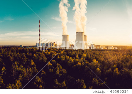 A Power plant with white smoke over it's chimneys A Power plant with white smoke over it's chimneys 49599034