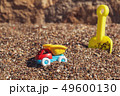 Children's toy truck with gravel or sand. Yellow scoop on the background. Concept of transportation 49600130