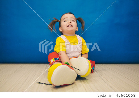 a little girl with two tails and huge shoes 49601058