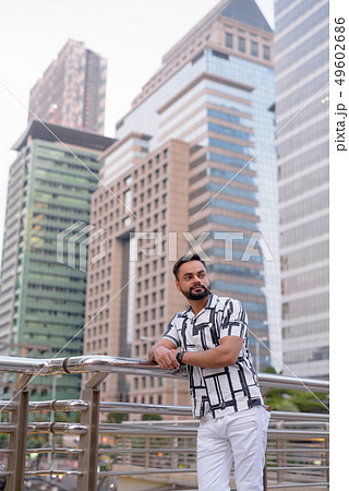 Young bearded Indian man thinking against view of the city 49602686