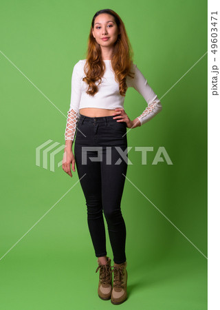 Young beautiful Asian woman against green background Young beautiful Asian woman against green background 49603471