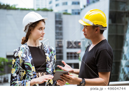 Young woman engineer discussing with worker Young woman engineer discussing with worker 49604744