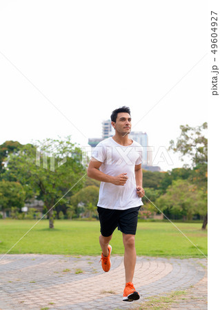 Full body shot of young handsome Hispanic man jogging at the park Full body shot of young handsome Hispanic man jogging at the park 49604927
