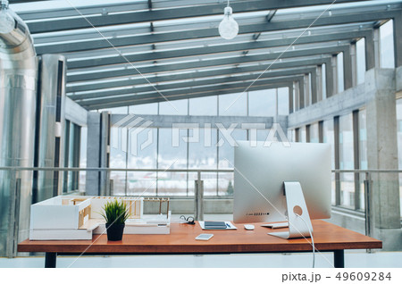An interior of a desk with computer in modern spacious office. 49609284