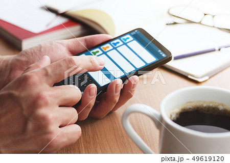 SNSアプリのイメージ。スマトフォンでメッセージを送る男性の手のアップ。 49619120