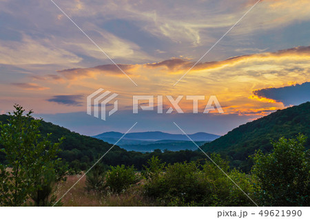 scenic sunset over the clouds between the green wo scenic sunset over the clouds between the green wo 49621990