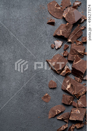Frame or border made of Dark or milk organic chocolate pieces on dark concrete backgound Frame or border made of Dark or milk organic chocolate pieces on dark concrete backgound 49627874