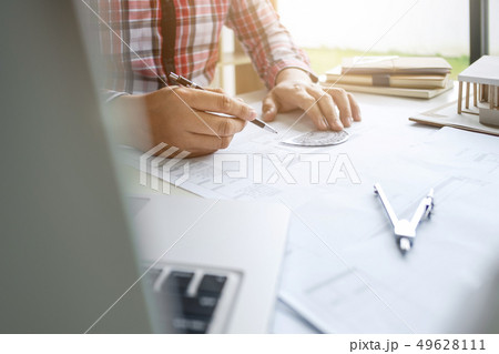 close up of male interior Architect working on blueprint with en 49628111