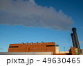 Thick smoke exiting two chimneys is winter 49630465