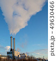 Thick smoke exiting two chimneys is winter 49630466