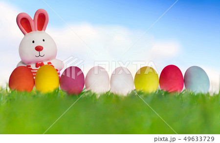 Easter rabbit with eggs on green grass under blue 49633729