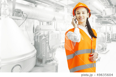 Destroying gender stereotypes. Female builder standing against industrial background 49635604