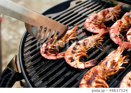 Man cooking the grilling big tiger shrimps prawns 49637524