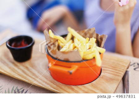 Blurry photo with soft focus on French fries in orange pan. Blurry photo with soft focus on French fries in orange pan. 49637831