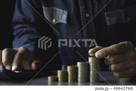 Hand drop a coin with money coin stack growing for 49642769