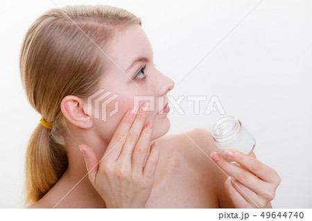 Woman applying face cream with her finger 49644740