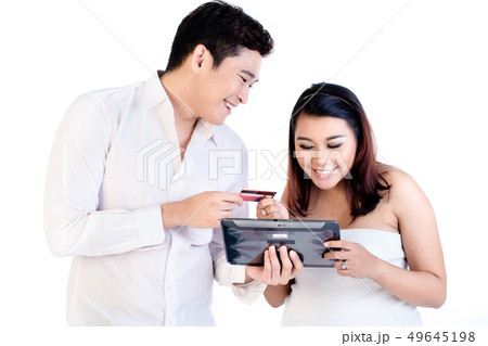 Man and his pregnant wife shopping online using digital tablet 49645198