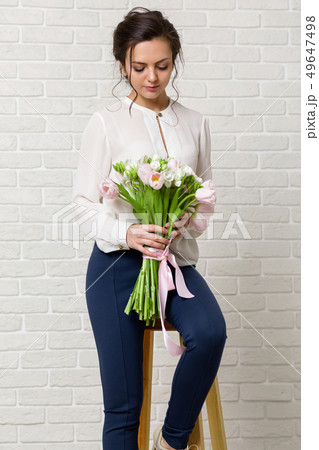 beautiful brunette woman with a bouquet of tulips flowers 49647498