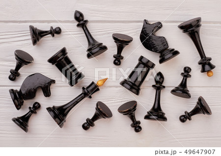 Black chess pieces lying on white background. Black chess pieces lying on white background. 49647907