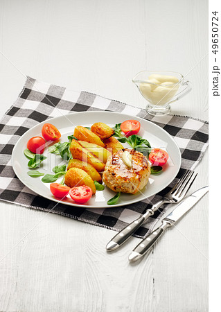 Fried chicken cutlet with roasted potato slices  49650724