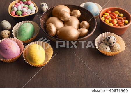 Colourful eggs and candies on dark background Colourful eggs and candies on dark background 49651969