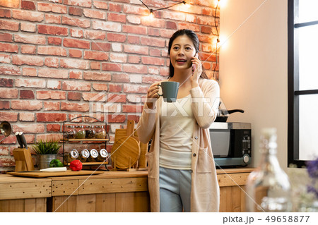 asian woman with coffee and talking on cellphone asian woman with coffee and talking on cellphone 49658877