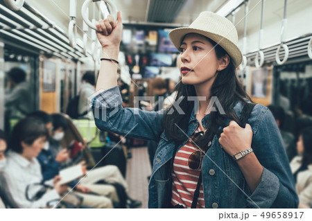 woman taking metro standing holding handle 49658917