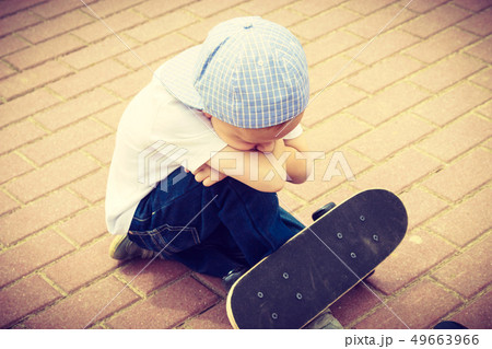 Lonely sad child with skateboard. Loneliness. Lonely sad child with skateboard. Loneliness. 49663966