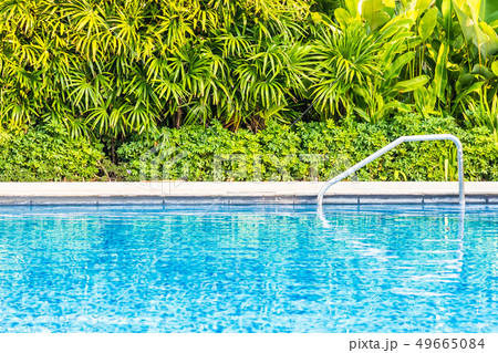 Beautiful outdoor swimming pool with bed deck chair and umbrella in resort for travel and vacation 49665084