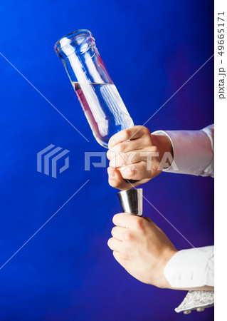 Filling shot glass from bottle. Filling shot glass from bottle. 49665171