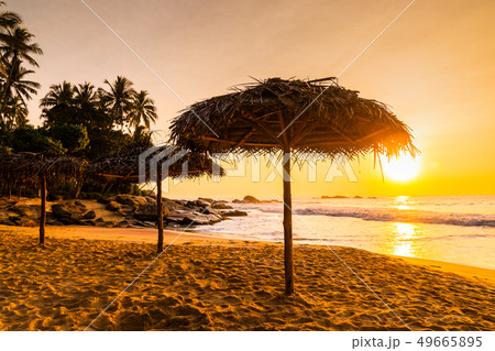 Two beach umbrellas at sunrise on a sandy beach. Tropical island. Two beach umbrellas at sunrise on a sandy beach. Tropical island. 49665895