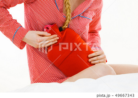 Woman feeling stomach cramps lying on bed Woman feeling stomach cramps lying on bed 49667343