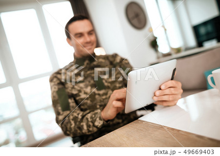 Smiling Military Man Uses Tablet in Living Room 49669403