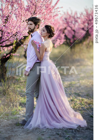Beautiful wedding couple in the gardens of a blossoming peach. Beautiful wedding couple in the gardens of a blossoming peach. 49673436
