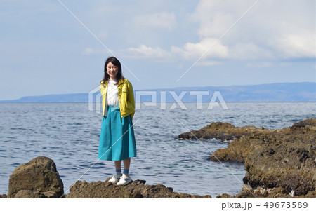 北海道せたな町長磯海岸で黄色いジャケットに青いスカート黒髪の女性のポートレートを撮影 49673589