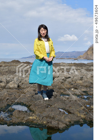 北海道せたな町長磯海岸で黄色のジャケットに青いスカート黒髪の女性のポートレートを撮影 北海道せたな町長磯海岸で黄色のジャケットに青いスカート黒髪の女性のポートレートを撮影 49673604