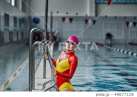 Portrait of a smiling woman swimmer in red yellow Portrait of a smiling woman swimmer in red yellow 49677128