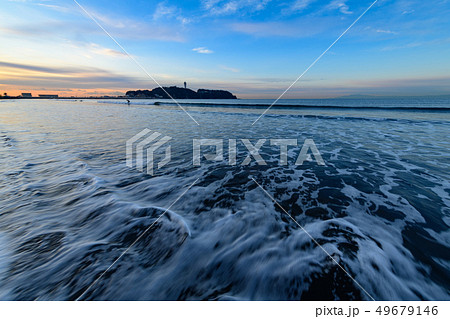 早朝の湘南江の島を片瀬西浜の波打ち際で眺める 49679146