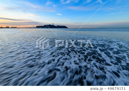 早朝の湘南江の島を片瀬西浜の波打ち際で眺める 49679151