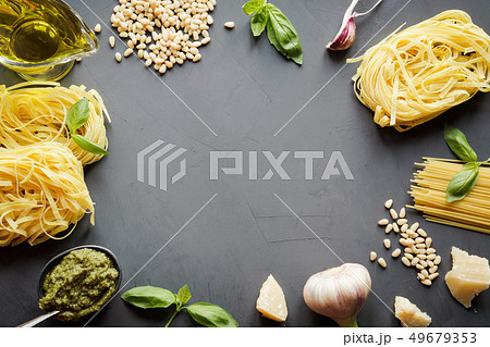 Border of raw pasta, pesto, basil, parmesan. 49679353