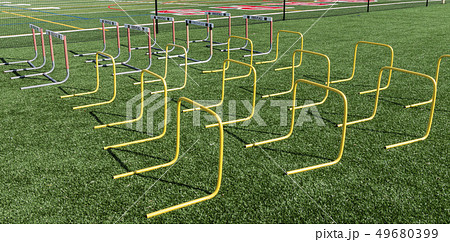 Hurdles set up on turf field for strength and 49680399