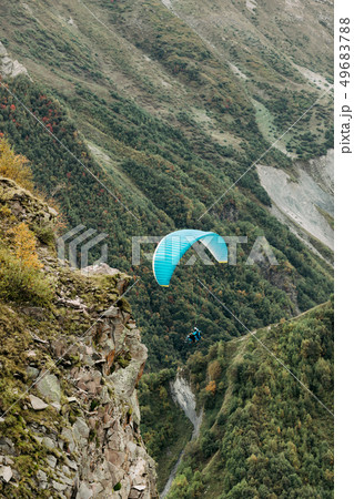 paraglider fly over mountain on a sunny day. paraglider fly over mountain on a sunny day. 49683788