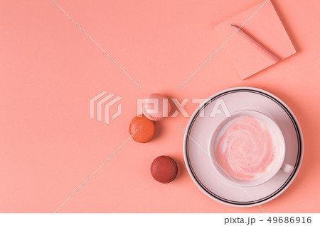 Cup of coffee with macaroons on pastel background. 49686916