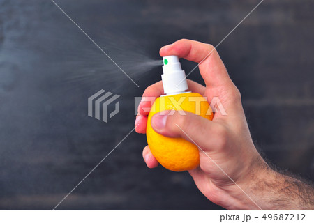 Man sprinkles juice from lemon with help of pump Man sprinkles juice from lemon with help of pump 49687212