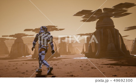 Astronaut goes on the surface of Mars through a dust storm past the giant solar panels. Panoramic 49692300