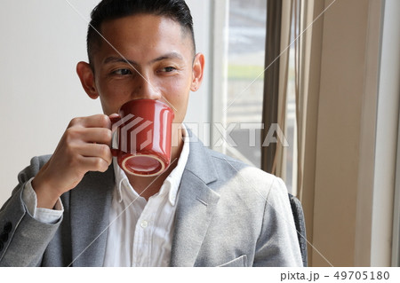 コーヒーを飲み窓の外を見るビジネスマン 49705180
