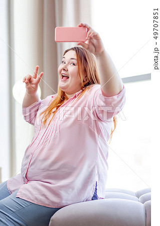 Positive happy plump woman posing for a selfie 49707851